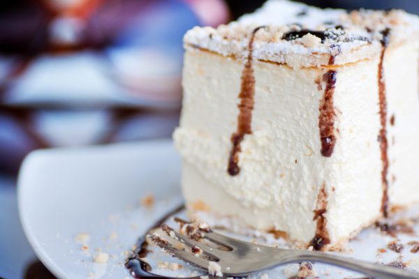 Close up of a cream pie decorated with hazelnut and melted chocolate